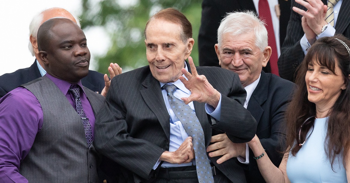 Bob Dole standing with men and women