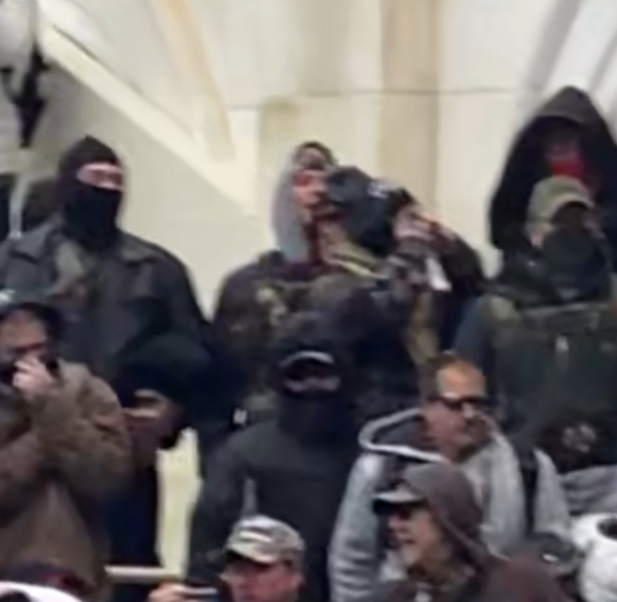 Suspicious group of what appears to be Patriot group affiliates with potential ties to the FBI or federal law enforcement observing the violence to the left of the Capitol building doors – Source: National File