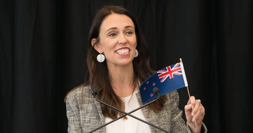 Jacinda Ardern holding New Zealand flag