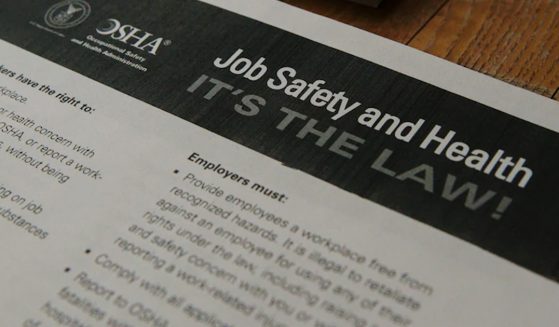 Piece of paper with OSHA's logo and "Job safety and health it's the law"